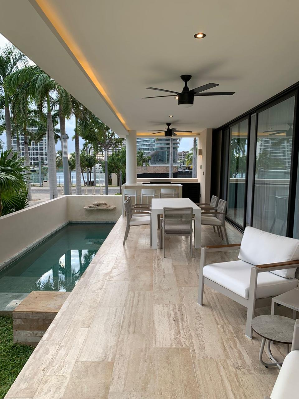 Terraza con alberca y comedor exterior de Residencia Lote 20, frente a la marina de Puerto Cancún