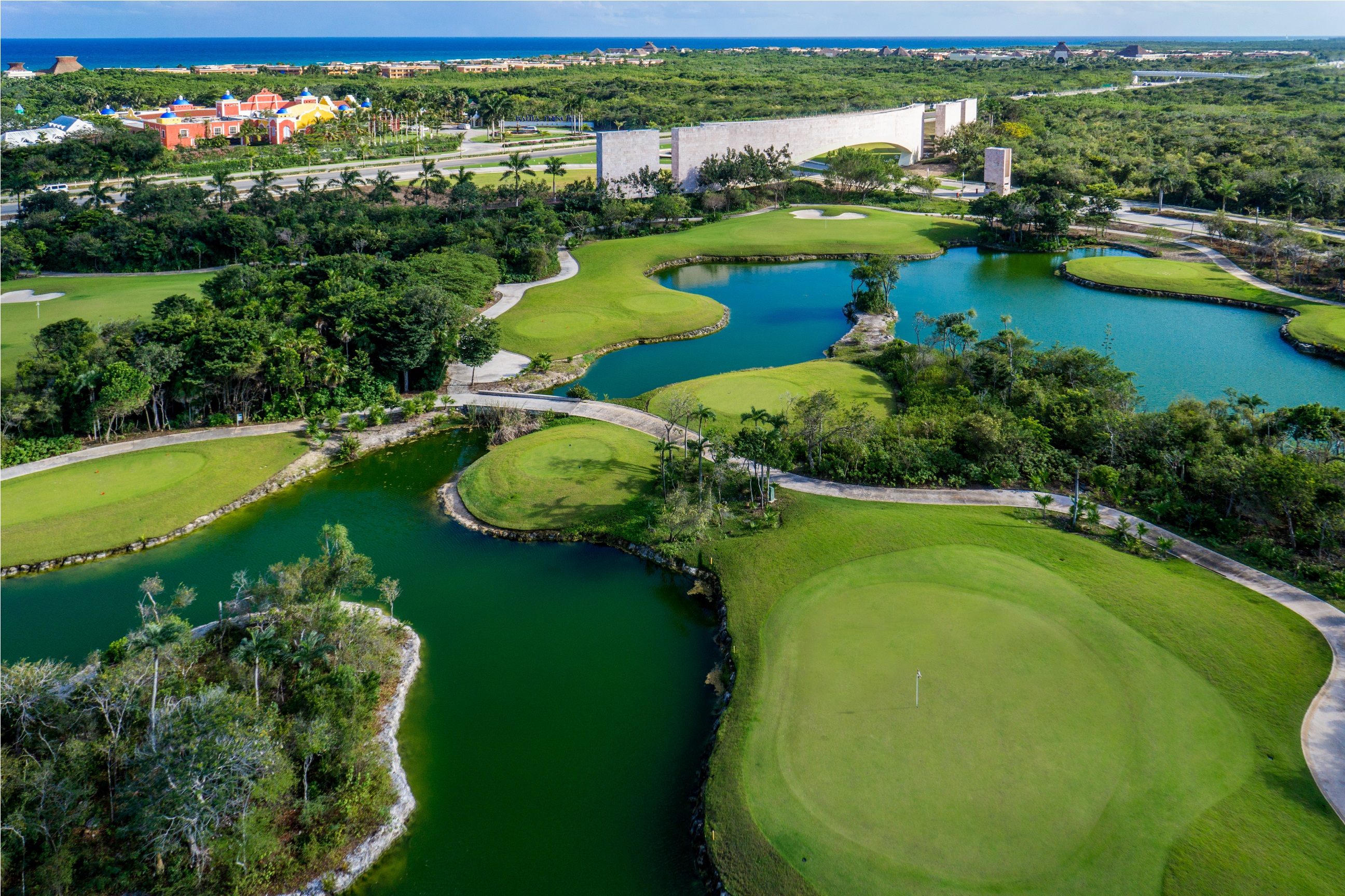 Vista aérea de Tulum Country Club: campo de golf, lagunas, selva y el mar Caribe al fondo