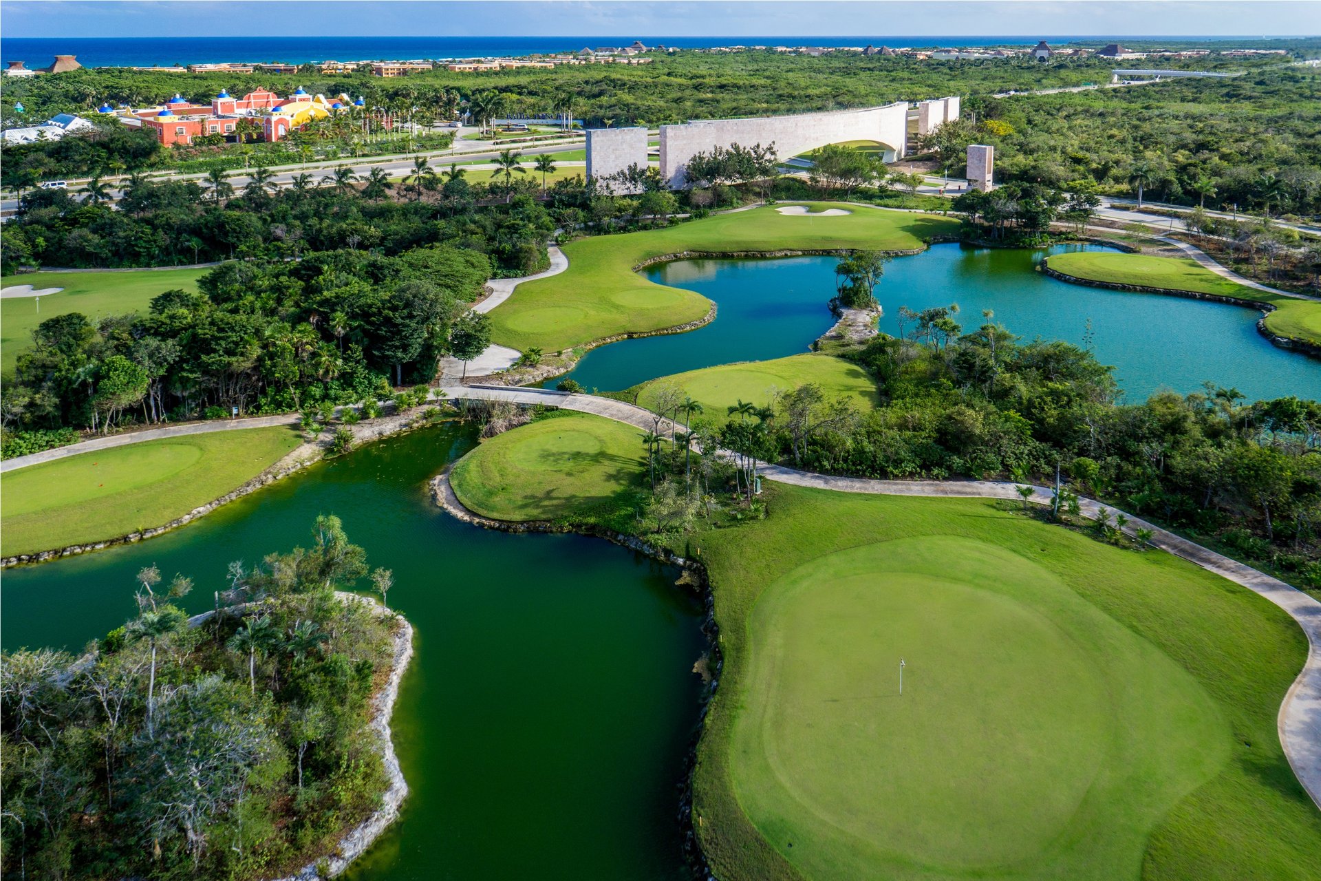 Vista aérea de Tulum Country Club: campo de golf, lagunas, selva y el mar Caribe al fondo